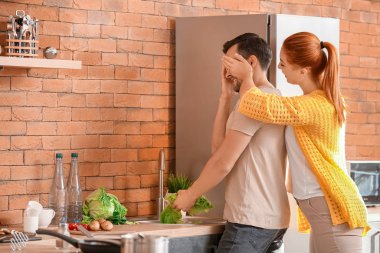 Mutlu çift evde mutfakta eğleniyor.