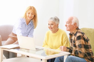 Bayan emlakçı içeride yaşlı bir çiftle çalışıyor.