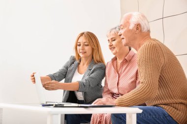 Bayan emlakçı içeride yaşlı bir çiftle çalışıyor.