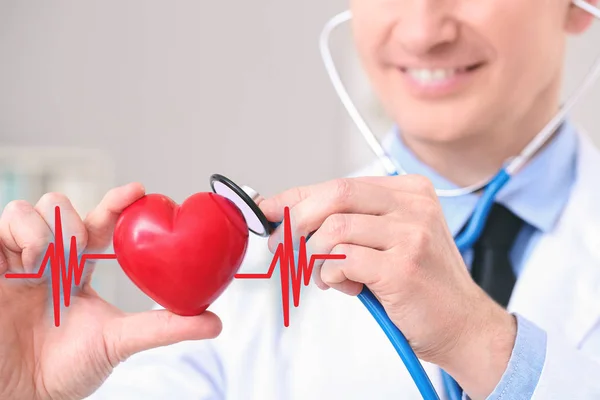 Muž kardiolog s červeným srdcem v moderní klinice, detailní záběr — Stock fotografie