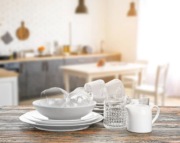 Set of clean dishes on wooden table in modern kitchen — 스톡 사진