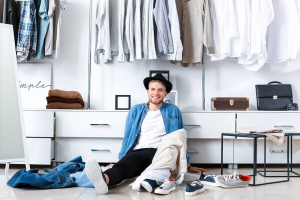 Handsome man choosing clothes in dressing room