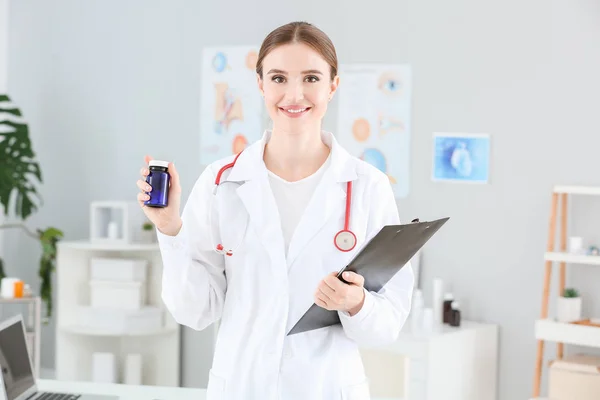 Retrato de médico feminino com pílulas na clínica — Fotografia de Stock