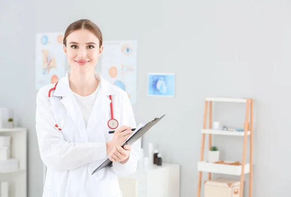 Portret van vrouwelijke arts met klembord in kliniek — Stockfoto