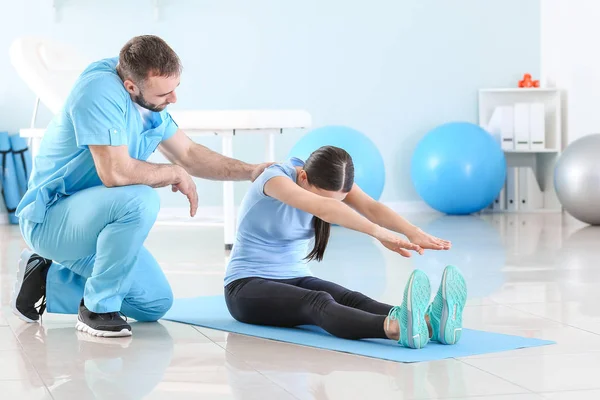 Physiotherapist working with female patient in rehabilitation center — Stock Photo, Image