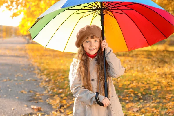 Petite fille mignonne avec parapluie dans le parc d'automne — Photo