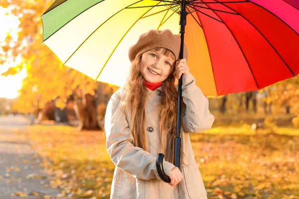 Cute little girl with umbrella in autumn park — Stock Photo, Image