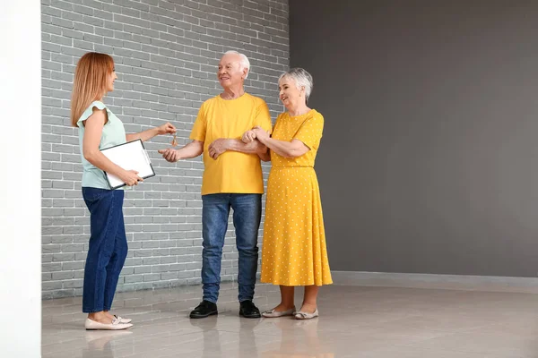Agente de bienes raíces dando una llave de la casa nueva a la pareja de ancianos —  Fotos de Stock