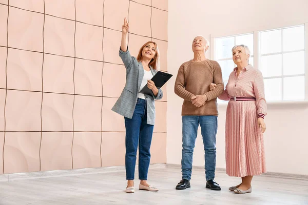 Vrouwelijke makelaar toont senior koppel een nieuw huis — Stockfoto