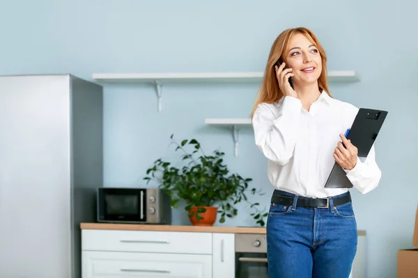 Agente inmobiliario femenino hablando por teléfono móvil en interiores — Foto de Stock