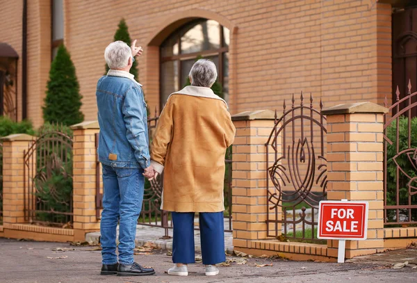 Senior couple near their new house — Stock Photo, Image