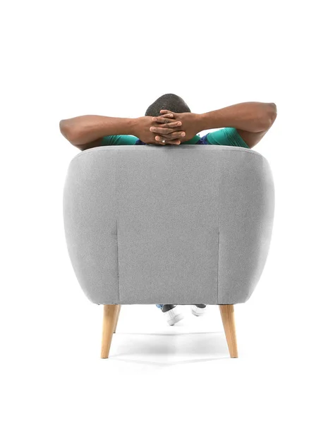 Afrikanisch-amerikanischer Mann entspannt im Sessel vor weißem Hintergrund, Rückseite — Stockfoto