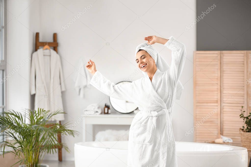 Beautiful young woman dancing in bathroom
