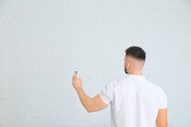 Klimalı genç adam arka planda uzaktan kumandalı