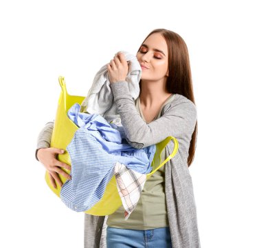 Beautiful young woman with laundry on white background