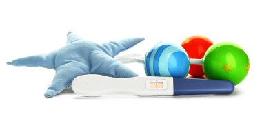 Hamilelik testi ve beyaz arka planda oyuncaklar