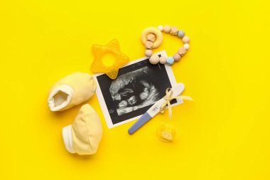 Hamilelik testi, ultrason görüntüsü, bebek paçası ve renkli arka plan oyuncakları.