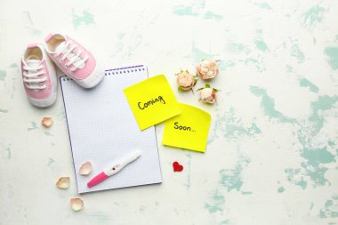 Hafif arkaplanda hamilelik testi ve defter kompozisyonu