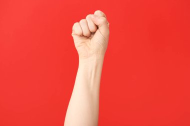 Renkli arka planda yumruğunu sıkmış bir kadın eli