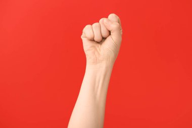 Renkli arka planda yumruğunu sıkmış bir kadın eli