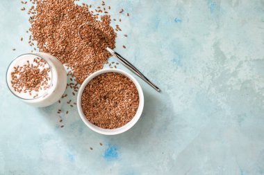 Keten tohumlu kase ve arka planda bir bardak yoğurt.