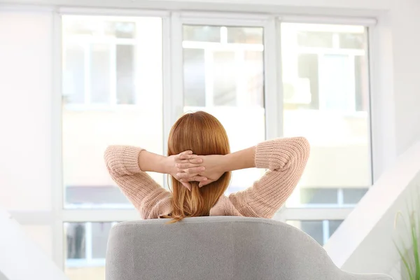 Schöne Frau entspannt sich im Sessel zu Hause — Stockfoto