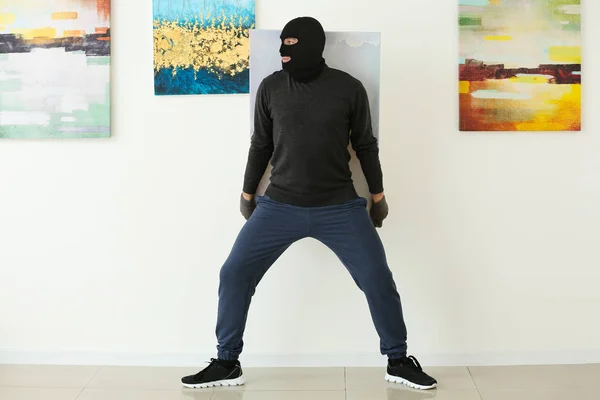 Thief stealing picture from art gallery