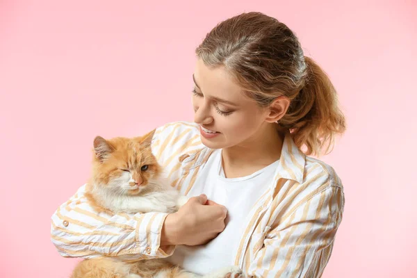 Schöne junge Frau mit niedlicher Katze auf farbigem Hintergrund — Stockfoto