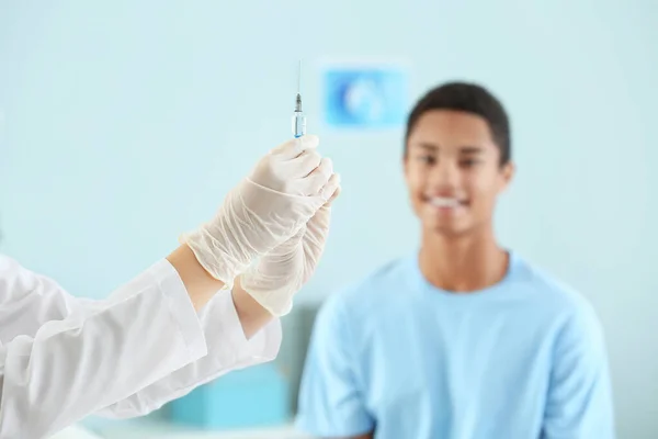 Läkare med vaccin i spruta beredd för injektion på klinik — Stockfoto