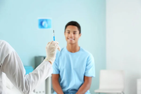 Doctor with vaccine in syringe prepared for injection in clinic — Stock Photo, Image