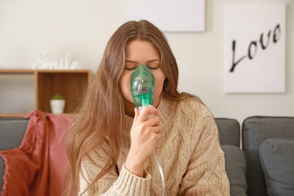 Sick young woman with inhaler at home — Stock Photo, Image
