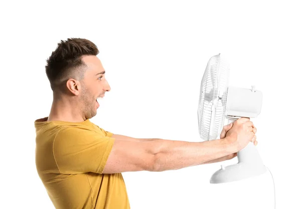 Jovem com ventilador elétrico sobre fundo branco — Fotografia de Stock