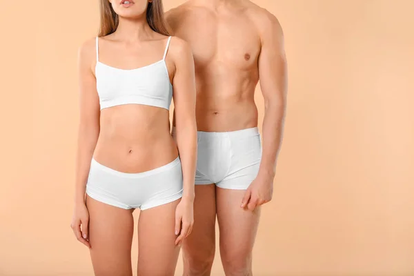Young couple in underwear on color background — 스톡 사진