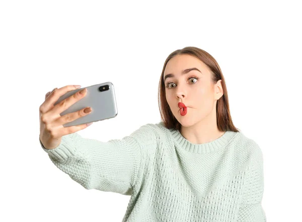 Mujer joven divertida tomando selfie sobre fondo blanco — Foto de Stock