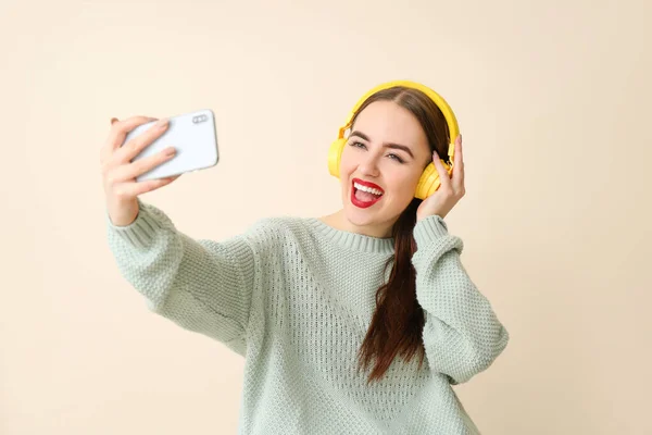 Schöne junge Frau macht Selfie auf farbigem Hintergrund — Stockfoto