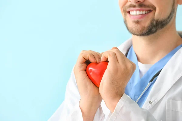 背景色に赤い心臓を持つ男性心臓病学者,クローズアップ — ストック写真