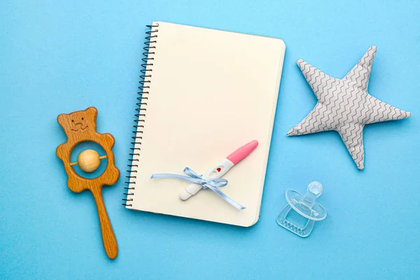 Graviditetstest, anteckningsbok och leksaker på färg bakgrund — Stockfoto
