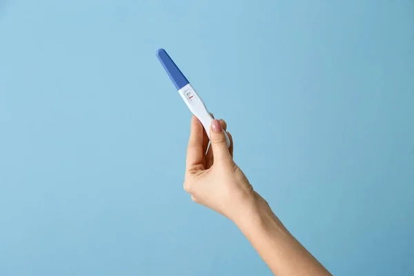 Female hand with pregnancy test on color background — Stock Photo, Image