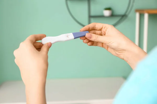 Молодая женщина с тестом на беременность дома — стоковое фото