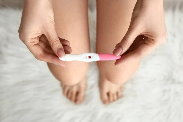 Młoda kobieta z test ciążowy w łazience — Zdjęcie stockowe