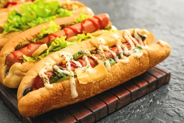 Chutné hot dogy na tmavém stole — Stock fotografie