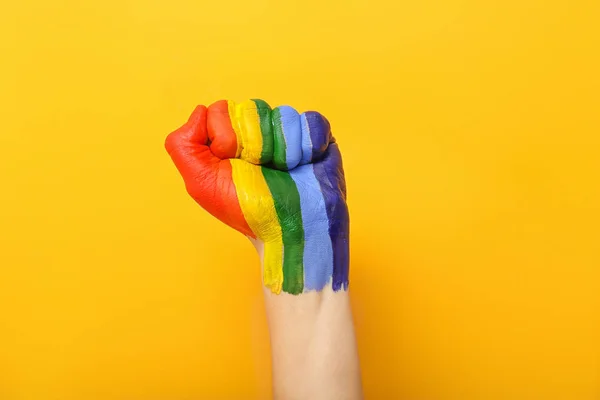 Main féminine avec arc-en-ciel peint sur fond de couleur. Concept LGBT — Photo