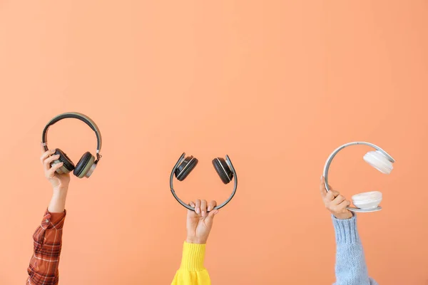 Hands with modern headphones on color background — Stock Photo, Image