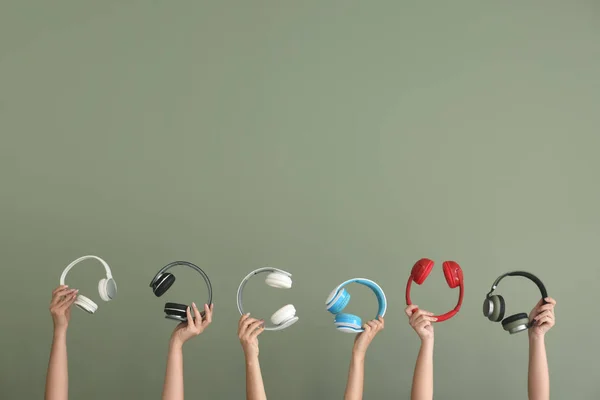 Hands with modern headphones on color background — 스톡 사진