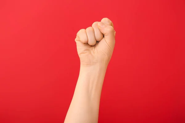 Hand of woman with clenched fist on color background — Stock Photo, Image