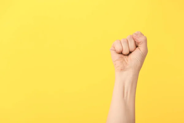 Hand of woman with clenched fist on color background — Stock Photo, Image