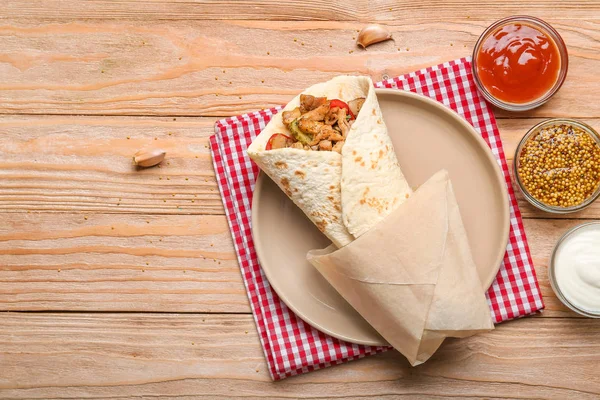 Sabroso kebab doner y salsas sobre fondo de madera —  Fotos de Stock