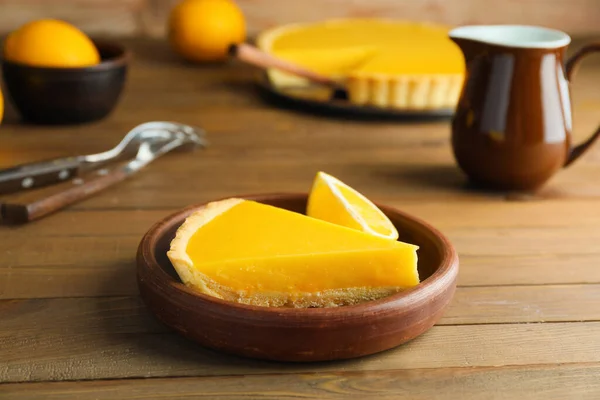 Placa com fatia de torta de limão saborosa na mesa — Fotografia de Stock