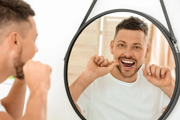 Handsome man flossing teeth at home — Stock Photo, Image