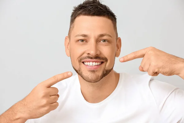 Handsome man with healthy teeth on light background — Stock Photo, Image